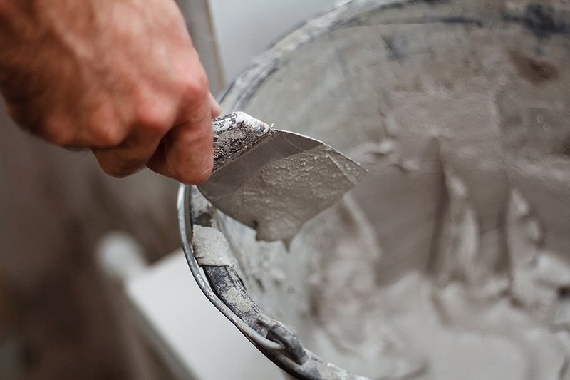 LANDU-hand-picks-up-plaster