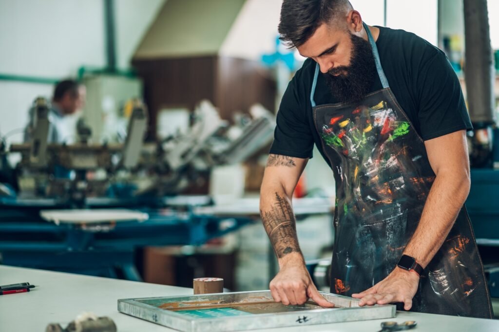 Male worker preparing screen printing film in a workshop