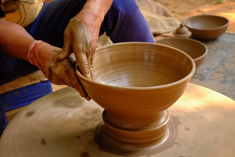 Pottery - skilled wet hands of potter shaping the clay on potter wheel